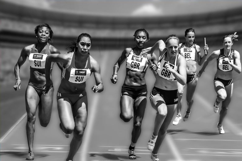 Women running a race down a running track.