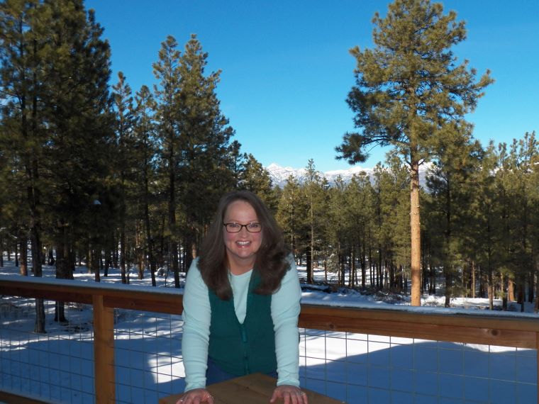 Author, Faith Richardson on deck with mountain background.