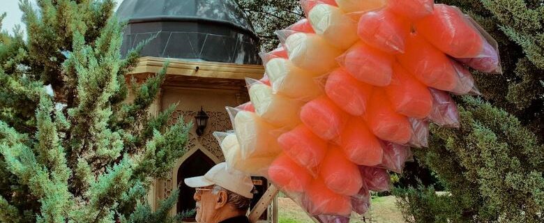 Man carrying cotton candy on a stick