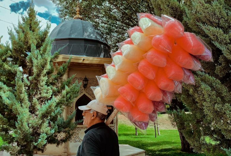 Man carrying cotton candy on a stick